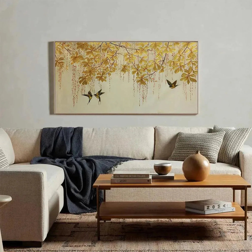 Golden Garden panoramic painting featuring golden leaves and birds in flight, displayed above a sofa in a lifestyle setting.