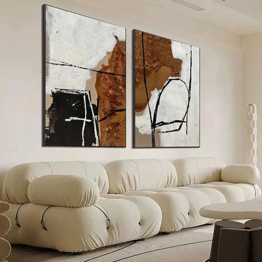 Javier Ramirez diptych: abstract brown, white, cream vertical paintings with textured brushstrokes & black lines in living room.