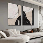 Two vertical abstract paintings with beige, black, white organic shapes and thin lines in a modern living room setting.