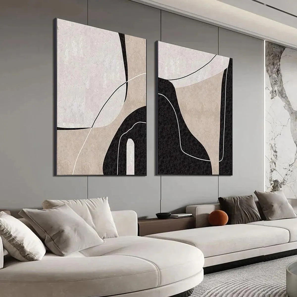 Two vertical abstract paintings with beige, black, white organic shapes and thin lines in a modern living room setting.