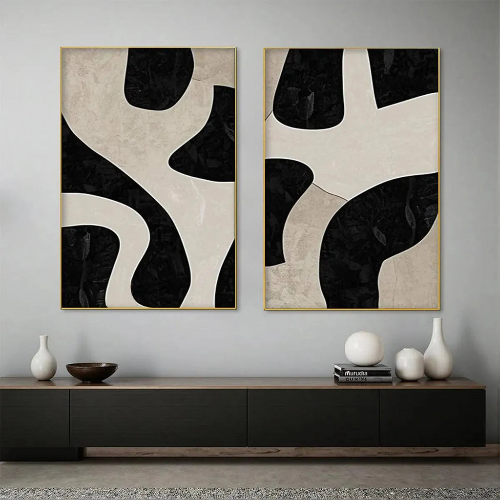Black and beige abstract diptych with organic geometric shapes in gold frames, minimalist wall art.