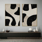 Black and beige abstract diptych with organic geometric shapes in gold frames, minimalist wall art.