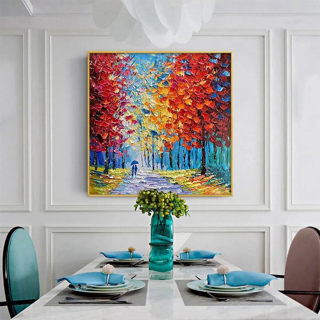 Textured impasto 'Autumn Walk' painting with vibrant red, orange, yellow trees and couple, in modern white dining room.