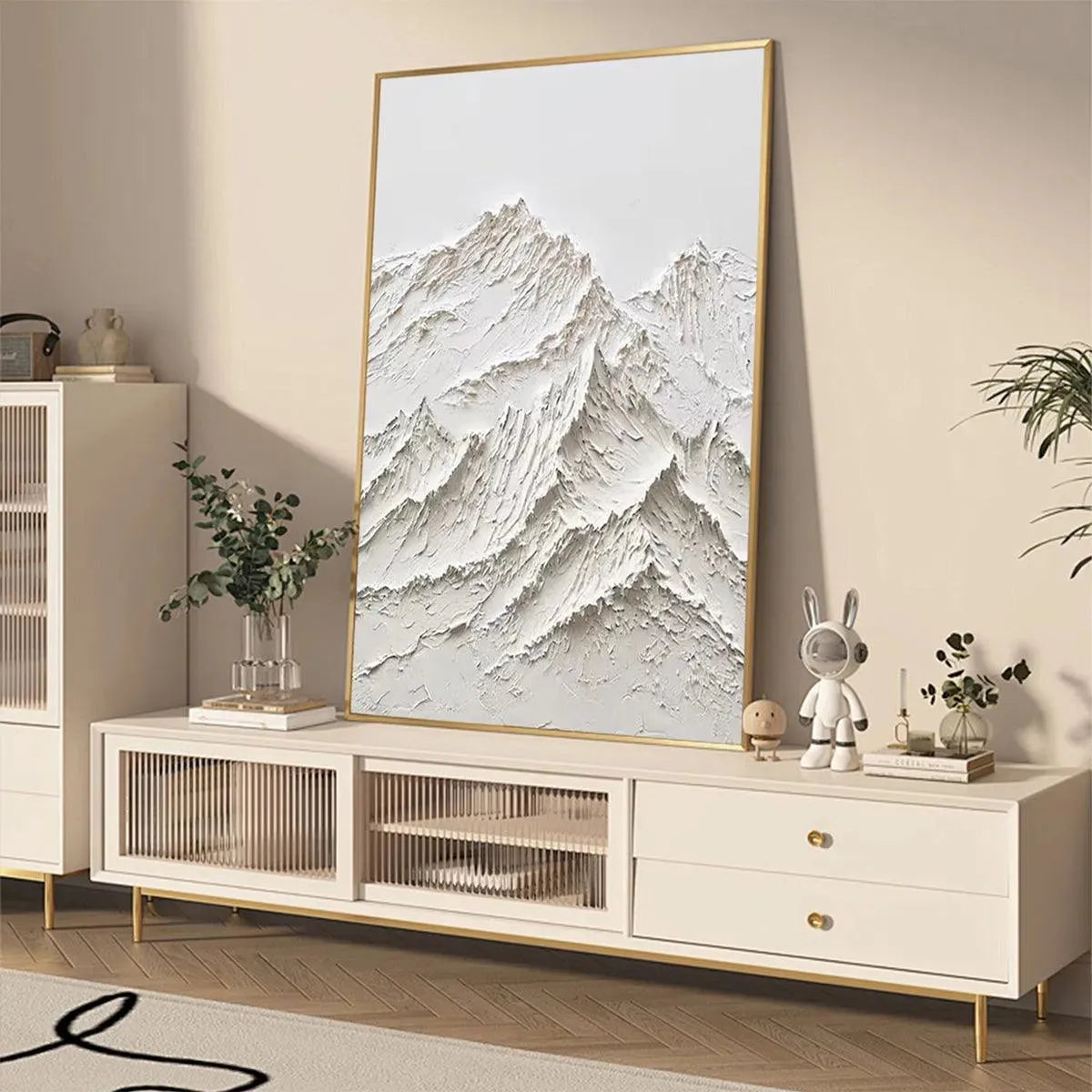 Textured white mountain painting by Liam O'Connell, impasto style with gold frame, shown in a living room.