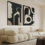 INK BLOT DUO: Set of 2 textured black and beige abstract paintings above cream sofa in living room.