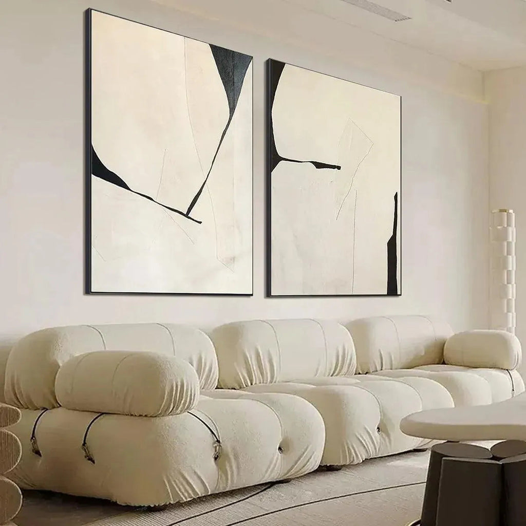 Minimalist abstract diptych, vertical wall art with black lines on beige background, displayed above cream sofa.