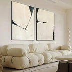 Minimalist abstract diptych, vertical wall art with black lines on beige background, displayed above cream sofa.