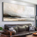 Misty Mountain Lake Panoramic artwork in muted earth tones above a brown leather sofa, showcasing serene landscape wall art.