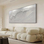 Liam O'Connell's Frozen Tide painting showcasing a textured white crashing wave above a cream sofa in a modern living room.