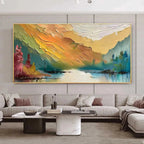 Large Isabella Rossi 'Autumn Valley' impasto landscape painting in gold frame above modern living room sectional.