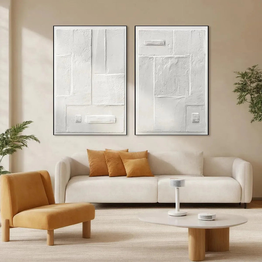 White textured diptych art by Javier Ramirez, minimalist abstract painting in a living room setting, vertical wall art.